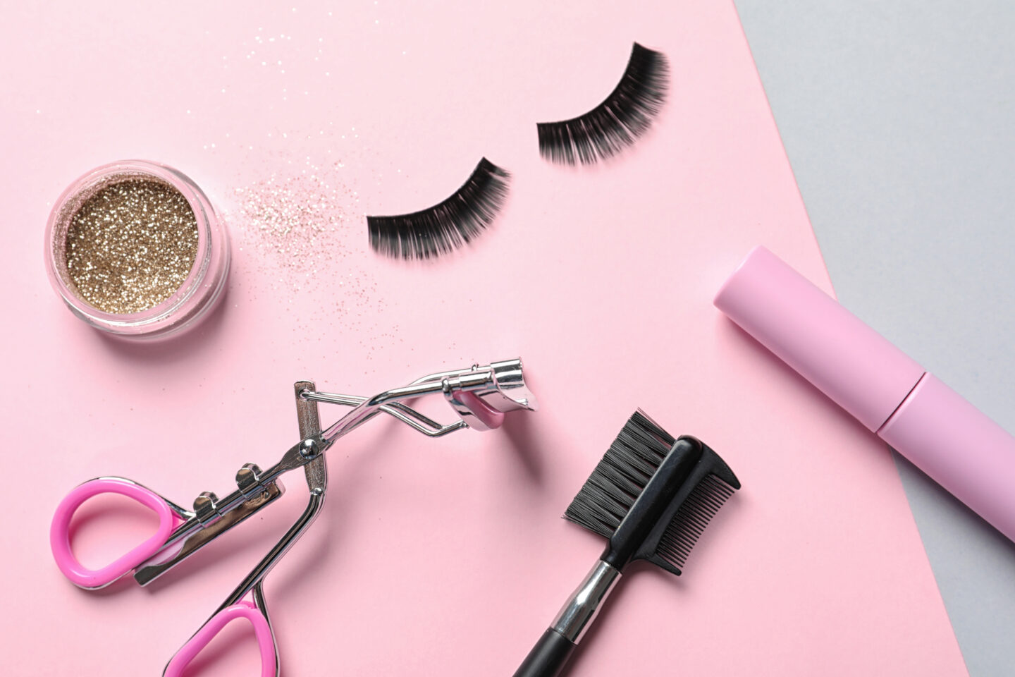 Flat lay composition with false eyelashes and other makeup products on color background